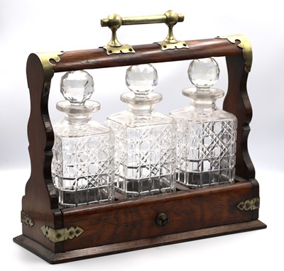 Lot 1286 - An Early XX Century Tantalus, in an oak stand...