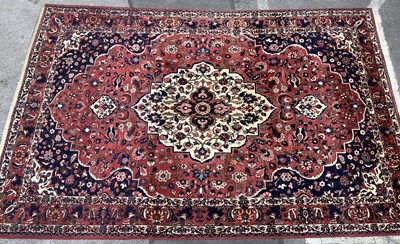 Lot 1485 - A large Oriental-style rug, with traditional...
